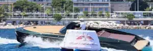 Frauscher Yacht fährt bei Tageslicht entlang der Küste von Monaco mit Yacht Club de Monaco Schleppboje im Vordergrund.