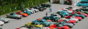 Oldtimer-Treffen mit exklusiven Klassikern von Ferrari, Porsche, Jaguar und weiteren historischen Sportwagen auf einem Außengelände.