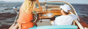 Klassische Riva-Yacht mit zwei Personen während der Ausfahrt des Riva-Treffens zwischen Monaco und Saint-Tropez an der Côte d'Azur.